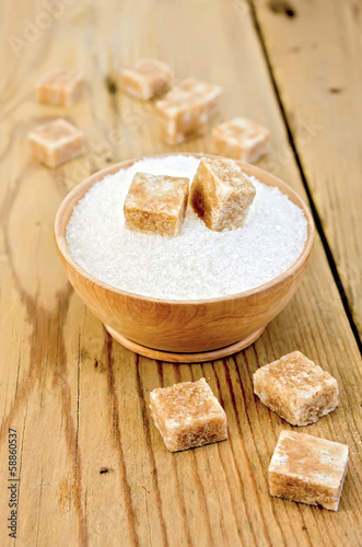 Photo: Sugar brown and white in a wooden bowl on a board Sugar brown and white in a wooden bowl on a board