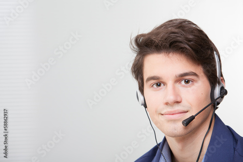 Photo: Portrait of a smiling call center employee wearing headset Portrait of a smiling call center employee wearing headset