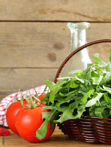 Photo: large bunch of arugula green salad on a wooden table large bunch of arugula green salad on a wooden table