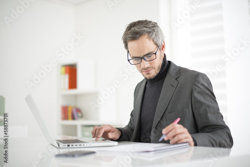 Photo: attractive man working in office attractive man working in office