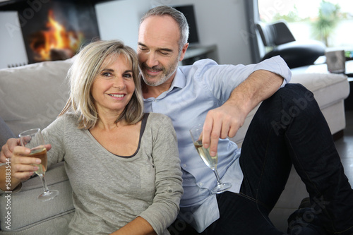 Photo: Happy senior couple enjoying glass of champagne Happy senior couple enjoying glass of champagne