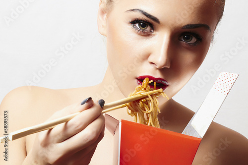 Photo: Beautiful woman are eating noodles.red lips.food delivery Beautiful woman are eating noodles.red lips.food delivery