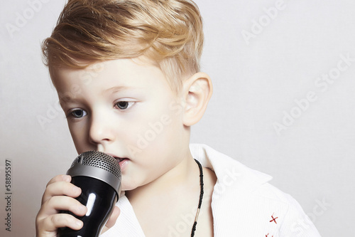 Photo: Little boy singing in microphone.child in karaoke.music Little boy singing in microphone.child in karaoke.music