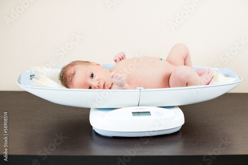 Photo: newborn baby on weighing scale newborn baby on weighing scale