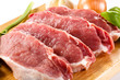 Raw pork on cutting board and vegetables Raw pork on cutting board and vegetables