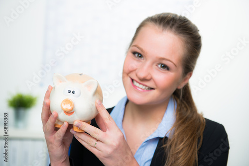 Photo: frau zeigt sparschwein frau zeigt sparschwein