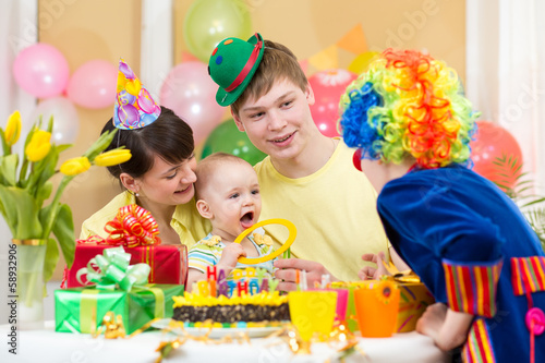 Photo: baby girl celebrating first birthday with parents and clown baby girl celebrating first birthday with parents and clown