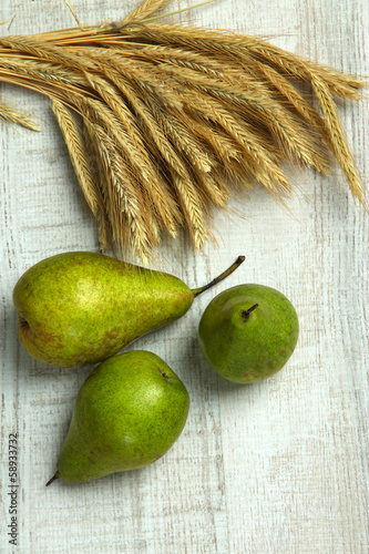 Photo: Pears and sheaf on wooden background Pears and sheaf on wooden background