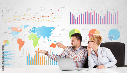 Photo: Business man and woman with colorful charts Business man and woman with colorful charts