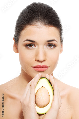 Photo: Beautiful woman's face with avocado. Beautiful woman's face with avocado.