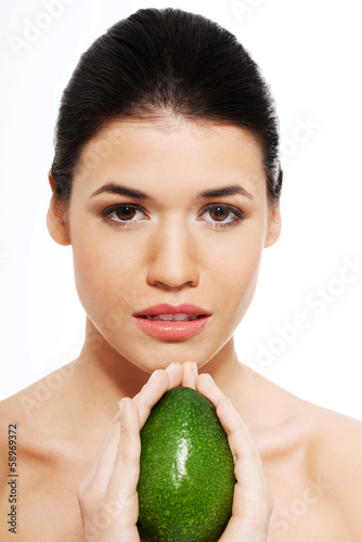 Photo: Beautiful woman's face with avocado. Beautiful woman's face with avocado.