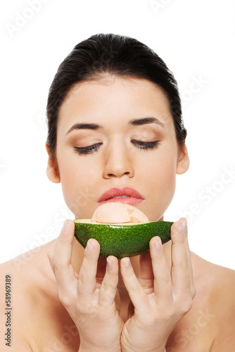 Photo: Beautiful woman's face with avocado. Beautiful woman's face with avocado.