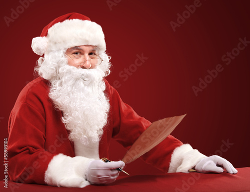 Photo: Portrait of Santa Claus looking at envelope in his hands Portrait of Santa Claus looking at envelope in his hands