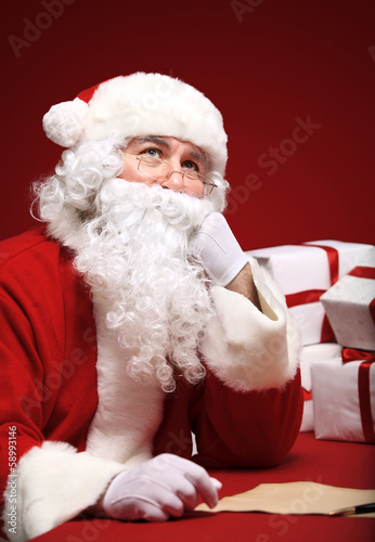 Photo: Portrait of Santa Claus looking at envelope in his hands Portrait of Santa Claus looking at envelope in his hands