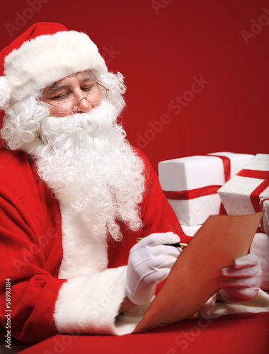 Photo: Portrait of Santa Claus looking at envelope in his hands Portrait of Santa Claus looking at envelope in his hands