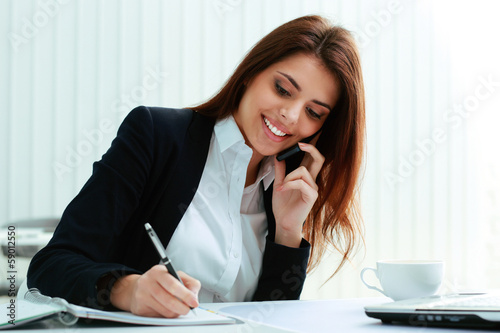 Photo: Young happy businesswoman talking on the phone Young happy businesswoman talking on the phone