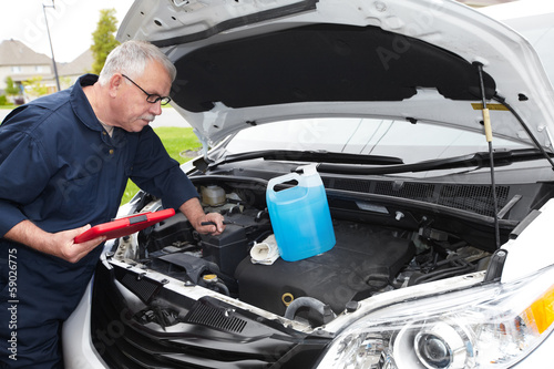 Photo: Auto mechanic checking engine. Auto mechanic checking engine.