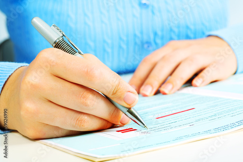 Photo: Business woman filling document. Business woman filling document.