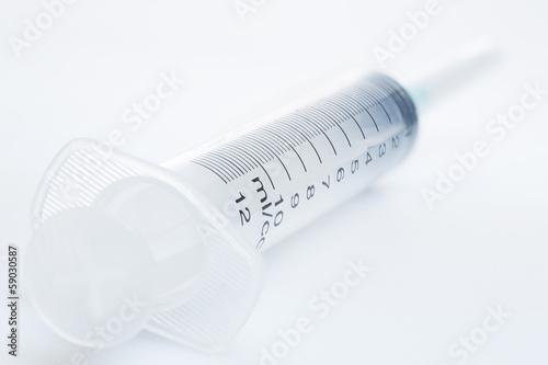 Photo: Plastic syringe on a white background Plastic syringe on a white background
