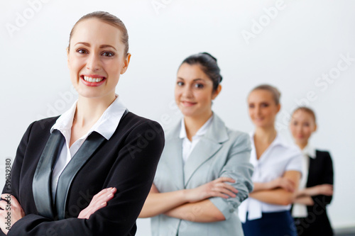Photo: Four businesswomen standing in row Four businesswomen standing in row