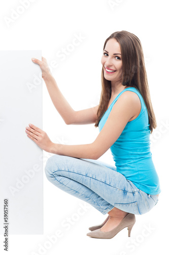 Photo: Woman crouching by blank board Woman crouching by blank board