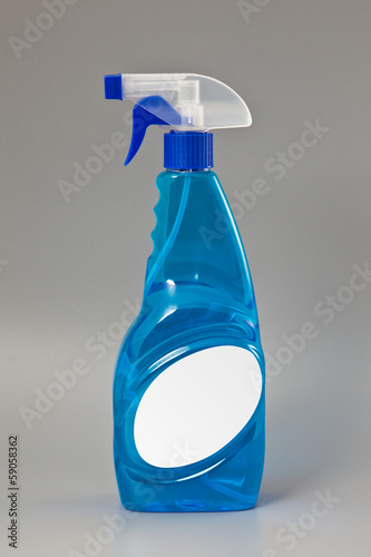 Photo: Blue transparent detergent spray bottle Isolated on gray Blue transparent detergent spray bottle Isolated on gray