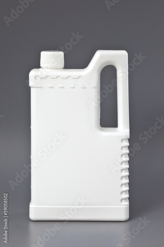 Photo: White detergent plastic bottle isolated on gray White detergent plastic bottle isolated on gray
