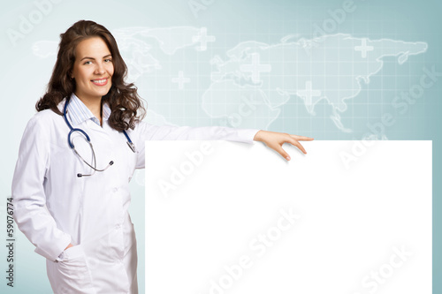 Photo: young woman doctor with a blank banner young woman doctor with a blank banner