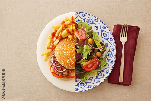 Photo: Low fat salad against greasy burger Low fat salad against greasy burger