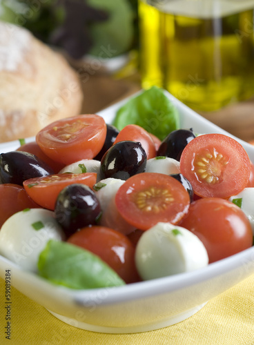 Photo: salad with tomato, mozzarella, basil and olives. salad with tomato, mozzarella, basil and olives.
