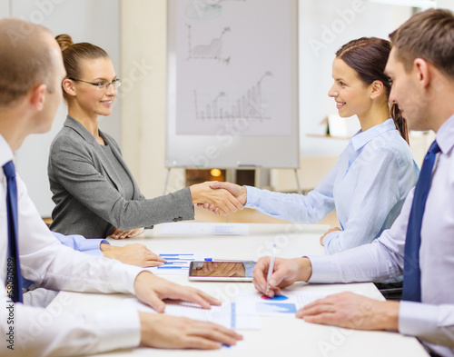 Photo: two businesswomen shaking hands in office two businesswomen shaking hands in office