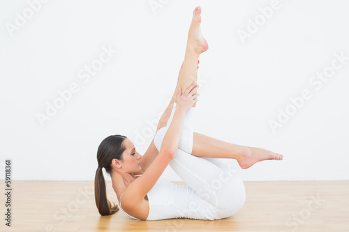 Photo: Fit woman stretching body in fitness studio Fit woman stretching body in fitness studio
