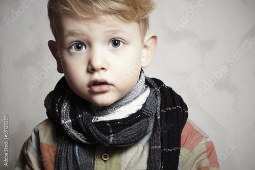 Photo: fashion handsome little boy in scarf.grunge background.haircut fashion handsome little boy in scarf.grunge background.haircut