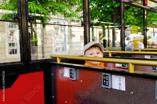Photo: Cute little boy riding in a bus or tram Cute little boy riding in a bus or tram