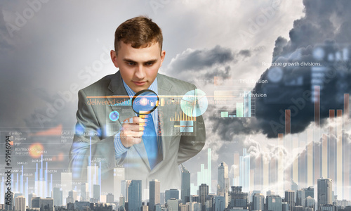 Photo: Man looking in magnifier Man looking in magnifier