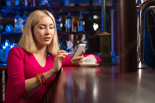 Photo: woman with a cup of coffee and cell phone woman with a cup of coffee and cell phone
