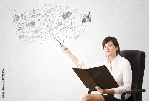Photo: Pretty girl sketching graphs and diagrams on wall Pretty girl sketching graphs and diagrams on wall