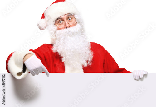 Photo: Santa Claus pointing in white blank sign with smile Santa Claus pointing in white blank sign with smile