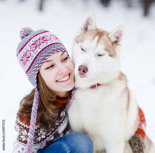 Photo: teen girl embracing cute dog in winter park teen girl embracing cute dog in winter park