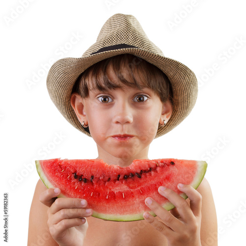 Photo: Cute girl in hat eats ripe watermelon Cute girl in hat eats ripe watermelon