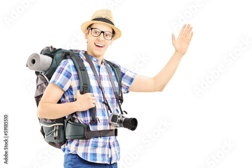Photo: Male tourist with backpack waving with his hand Male tourist with backpack waving with his hand