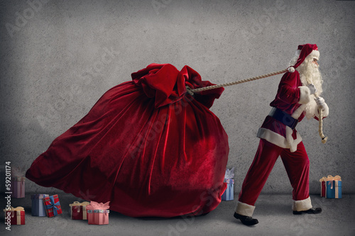 Photo: Santa Claus pulls a huge bag of gifts Santa Claus pulls a huge bag of gifts