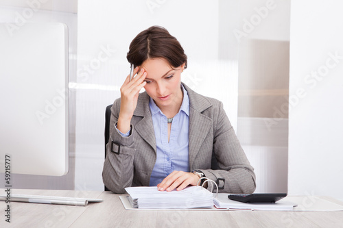 Photo: Thoughtful Businesswoman Doing Calculations Thoughtful Businesswoman Doing Calculations