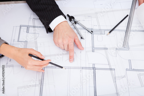 Photo: Person's Hand Pointing On Blue Print Person's Hand Pointing On Blue Print
