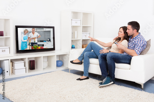 Photo: Young Couple Watching Television Young Couple Watching Television