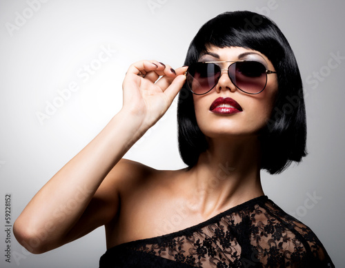 Photo: beautiful brunette woman with shot hairstyle with red sunglasses beautiful brunette woman with shot hairstyle with red sunglasses