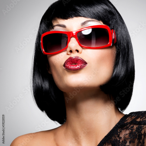 Photo: beautiful brunette woman with shot hairstyle with red sunglasses beautiful brunette woman with shot hairstyle with red sunglasses