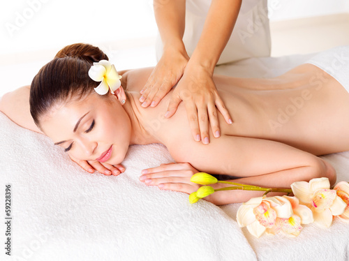 Photo: Woman having massage of body in spa salon Woman having massage of body in spa salon
