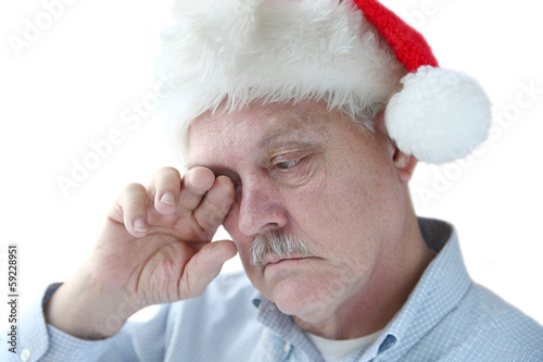 Photo: Santa hat on tired senior man Santa hat on tired senior man