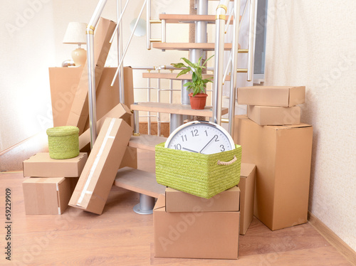 Photo: Stack of cartons near stairs: moving house concept Stack of cartons near stairs: moving house concept
